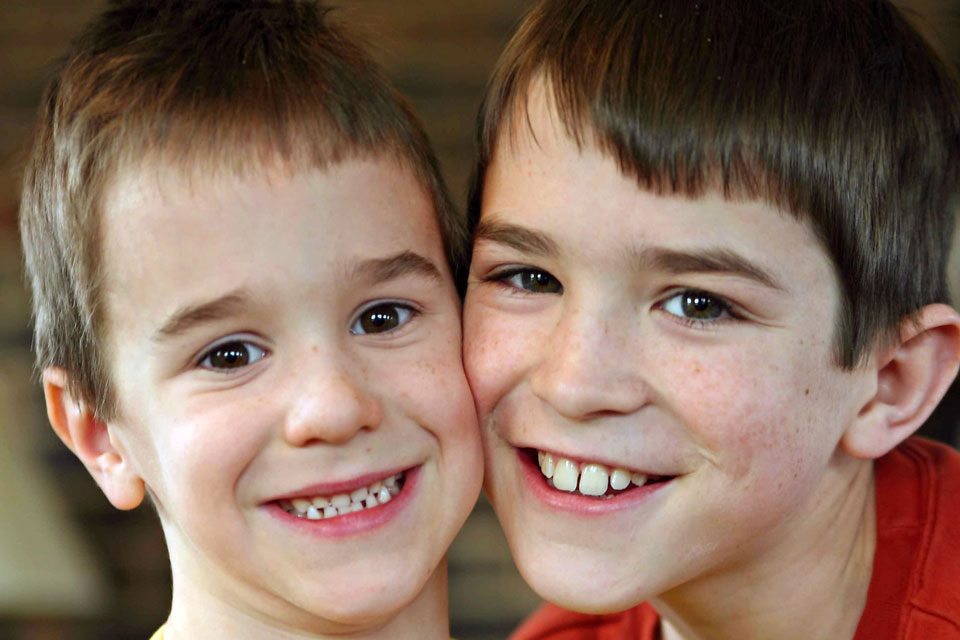 Two boys smiling cheek-to-cheek