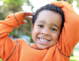 Boy smiling with orange shirt